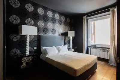 a bedroom with a bed with black walls and a window at 2 bedrooms flat near Via Veneto in Rome