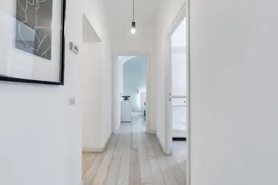 a hallway with white walls and wooden floors at Clemente XII Repubblica House - 3 Bedroom Apartment in Rome