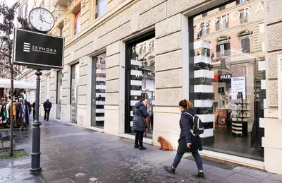 a woman walking down a street in front of a store at Bright Vatican Apartment in Rome