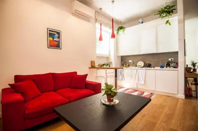 a living room with a red couch and a table at Perfect Hideout in Trastevere in Rome