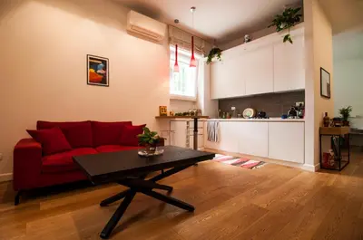 a living room with a red couch and a table at Perfect Hideout in Trastevere in Rome