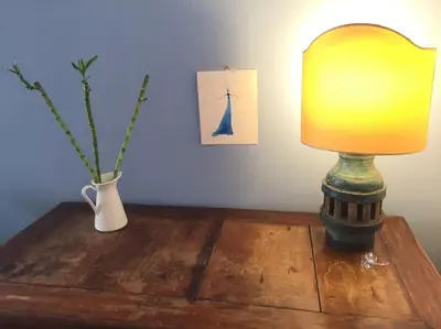 a lamp on a wooden table next to a vase at Vatican Dolce Vita in Rome