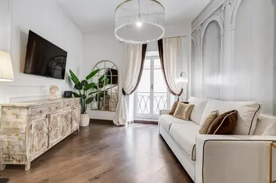 a living room with a white couch and a tv at NEXT TO SPANISH SQUARE - RomeDreamHome in Rome