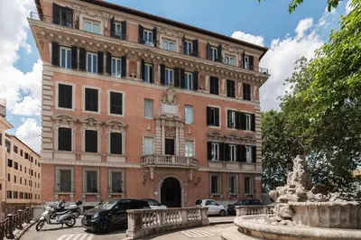 a large brick building with cars parked in front of it at JOIVY Window on the Tevere in Rome