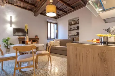 a kitchen and living room with a table and a couch at 18 Ciancaleoni House in Rome