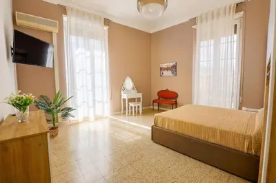 a bedroom with a bed and a chair and a television at Grazioli Vatican Home in Rome