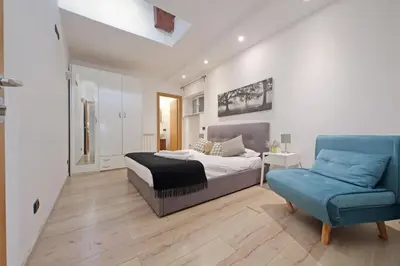 a bedroom with a bed and a blue chair at Monte del Gallo Apartment for groups in Rome