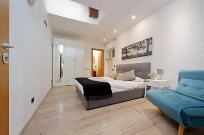 a bedroom with a bed and a blue couch at Monte del Gallo Apartment for groups in Rome