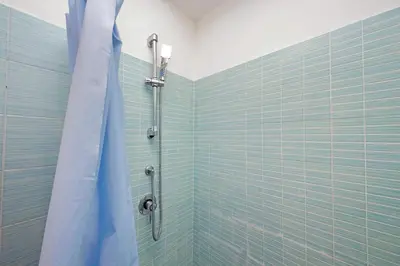 a bathroom with a shower with blue tiles at Monte del Gallo Apartment for groups in Rome