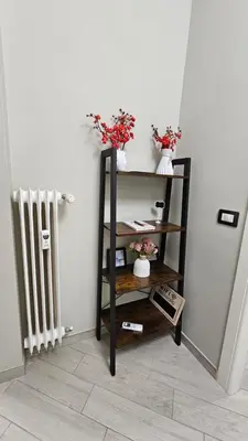 a shelf with flowers on it next to a radiator at AquariHome 6 Apartment in Rome
