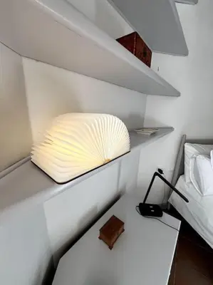 a room with a shelf with a pillow and a lamp at TrastevereMoroni Gem in Rome