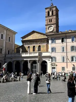 a group of people standing in front of a building with a clock tower at TrastevereMoroni Gem in Rome