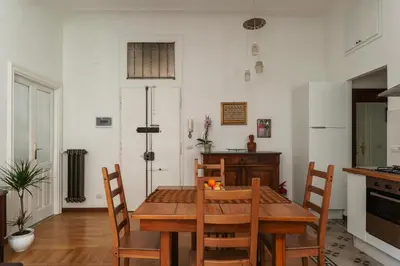 a dining room with a wooden table and chairs at Casa Dandolo - Pretty Homes in Rome