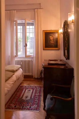a room with a bed and a table and a window at Appartamento Coppedè in Rome