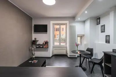 a living room with a table and chairs and a window at San Giovanni apartment in Rome