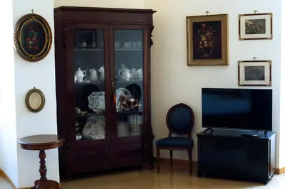 a wooden cabinet with dishes in it next to a television at Casa Salimei in Rome