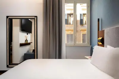 a bedroom with a large white bed and a mirror at Boutique Hotel Piedra Rome City Centre in Rome