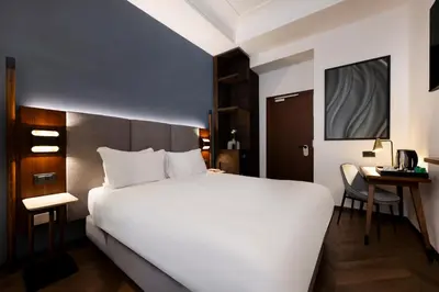 a bedroom with a large white bed and a desk at Boutique Hotel Piedra Rome City Centre in Rome