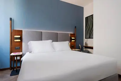 a bedroom with a large white bed and a desk at Boutique Hotel Piedra Rome City Centre in Rome