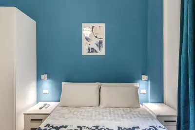 a blue bedroom with a bed and a blue wall at Orazio's Charming Apartment in Rome