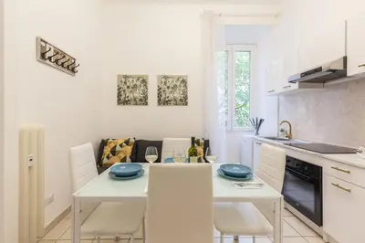 a white kitchen with a table and some chairs at Hostly-Michelangelo Cloister Suite-Center of Rome in Rome