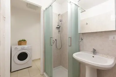 a bathroom with a sink and a washing machine at Hostly-Michelangelo Cloister Suite-Center of Rome in Rome