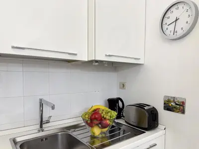 a kitchen with a sink and a clock on the wall at Banchi Vecchi Stay Apt Suite Pantheon in Rome