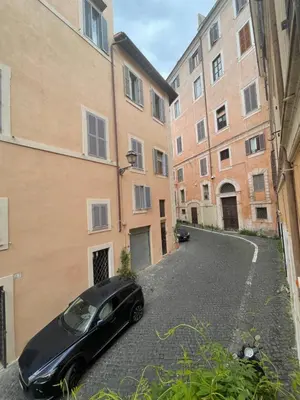 a black car parked in an alley between two buildings at A Den for Two in Rome