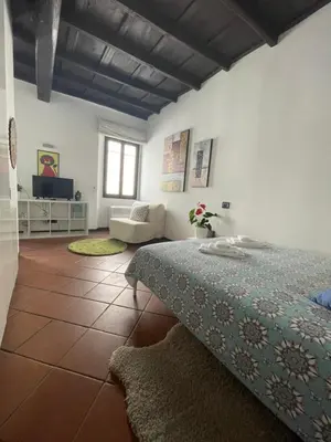 a bedroom with a bed and a living room at A Den for Two in Rome