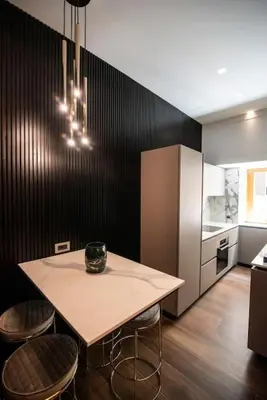 a kitchen with a table and some chairs and a refrigerator at Luxury Rhome Via della Croce in Rome