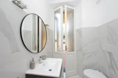 a white bathroom with a sink and a mirror at YCH-Comfortable 2 bedrooms flat near Colosseum in Rome