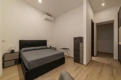 a bedroom with a bed and a chair in it at GuestHost - Trastevere Three Cozy Rooms in Rome
