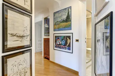 a hallway with framed art on the walls at Colosseo Family Art 3BDR - Home and More in Rome