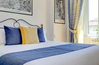 a bedroom with a bed with blue and yellow pillows at Colosseo Family Art 3BDR - Home and More in Rome