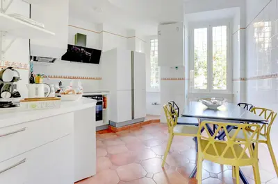 a kitchen with a table and yellow chairs at Colosseo Family Art 3BDR - Home and More in Rome