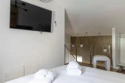 a white bedroom with a bed with two white towels at MauveSweetRhome 2 in Rome