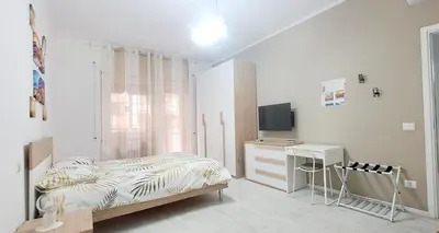a bedroom with a bed and a desk and a television at Amores Roma Apartment in Rome