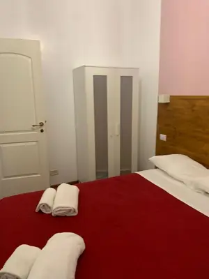 a bedroom with two white towels on a red bed at Domus Filiberto by Local Domus in Rome