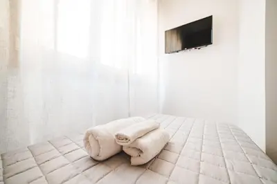 a white bedroom with a bed with towels on it at Tibur Domus B&B in Rome