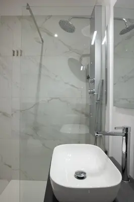 a bathroom with a white sink and a shower at Vatican 23 Museum Suites in Rome