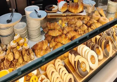 a display case with various types of bread and pastries at Augusto Imperatore Suite in Rome