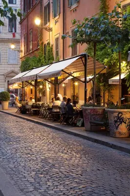 a group of people sitting at tables on a street at Augusto Imperatore Suite in Rome
