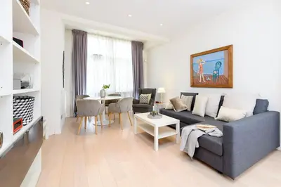 a living room with a blue couch and a table at San Pietro Nausicaa Penthouse in Rome