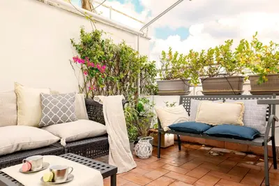 a patio with a couch and a table at San Pietro Nausicaa Penthouse in Rome