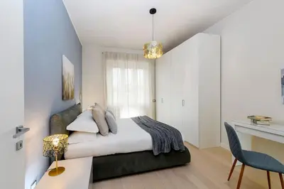 a bedroom with a bed and a table and a desk at San Pietro Nausicaa Penthouse in Rome