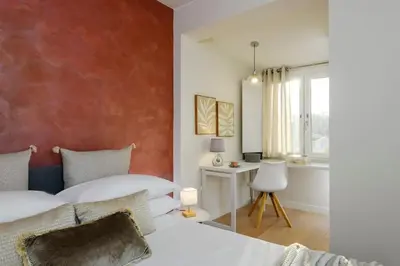 a bedroom with two beds and a desk and a window at San Pietro Nausicaa Penthouse in Rome