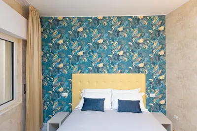 a bedroom with a large bed with a floral wallpaper at Flowery Rainbow in Rome