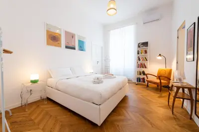 a white bedroom with a large bed and a desk at Boho 202 in Rome