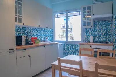 a kitchen with white cabinets and a wooden table at Delia's Vatican House Near St Peter's in Rome