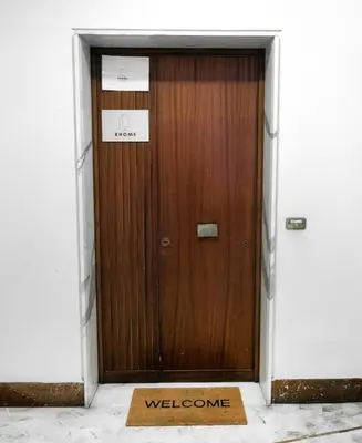 a wooden door with a welcome sign in front of it at RHOME SUITE VATICAN APTS in Rome